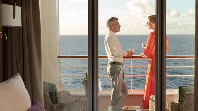 Couple standing on balcony of an Ambassador suite